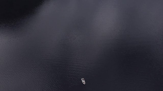 Turn the camera from top to bottom. Motor fishing boats with people in the sea. Magnificent landscape of Europe. Smooth surface of sea with ripple on the water. Sea creek is surrounded by mountains
