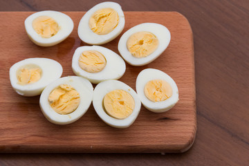 Boiled eggs on cutting board on wooden table