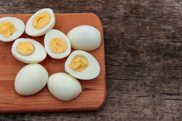 Boiled eggs on cutting board on wooden table