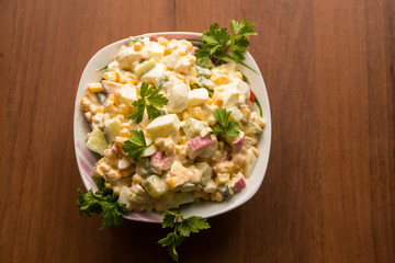 Salad with crab sticks, sweet corn, cucumber, eggs and mayonnaise