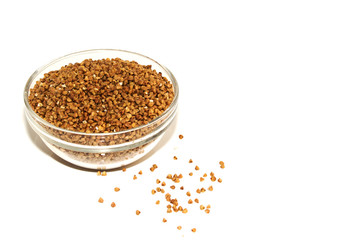 buckwheat in a glass bowl isolated on white.