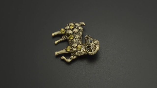 Copper brooch with diamonds aries isolated on black