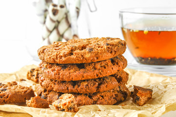 Homemade oatmeal cookies and tea on a wooden white table.