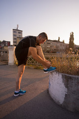 man tying running shoes laces