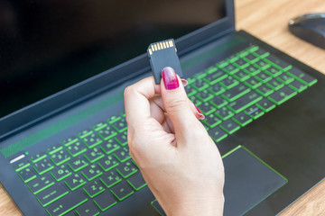 Hands Show Memory Card of Laptops user on working table desk