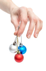 Female hand holding Christmas balls. Isolated on white.