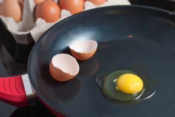 Broken egg with shell on a frying pan.