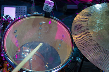 drum set with a wooden drumstick and music notes in concert studio