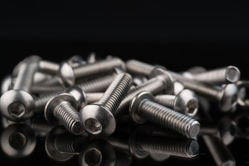 metal fasteners screws and nuts on black background. screw isolated on the black backgrounds. Nuts...