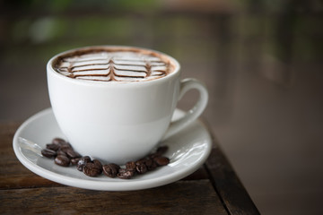 White coffee mug on patterned old wooden floor.