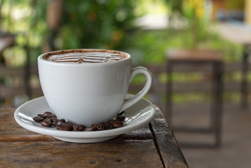 White coffee mug on patterned old wooden floor.