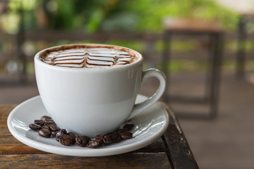 White coffee mug on patterned old wooden floor.