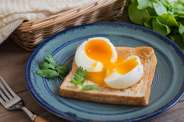 Soft boiled egg with toast on blue plate