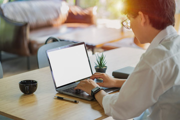 Male person sitting front open laptop computer with blank empty screen for your information or content,modern businessman work in internet via notebook, student at coffee shop learning