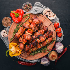Shish kebab on skewers with onions. On the black wooden table.