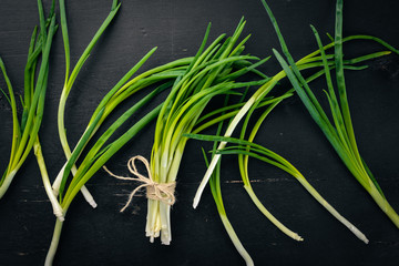 Fresh green onion on a wooden background. Top view. Free space for your text.