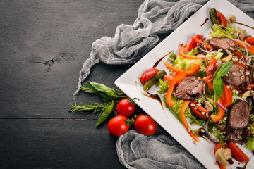 Veal Salad, Lettuce and Fresh Vegetables on the plate. On a wooden background. Top view. Free space for text.