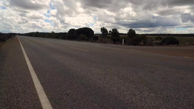 Auffahrt über Kreuzung auf einen Highway in West-Australien mit Kamerablickwinkel auf den linken Straßenrand