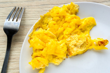 Scrambled egg on white plate. Top view.
