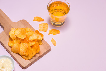 Cheese and onion potato chips with soft drink on pink background.