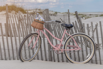 Pink bicycle on beach dunes in summer sun