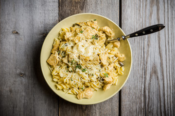 Fresh pasta with meat, mushrooms and herbs. On the rustic wooden background. Selective focus.