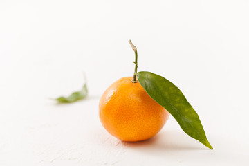 Fresh tangerines with green leaves on a white background