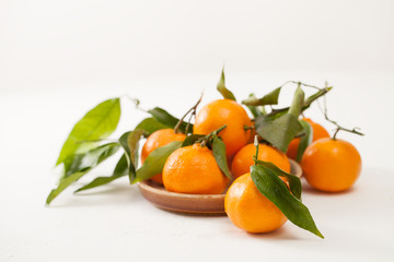 Fresh tangerines in a bowl on white background