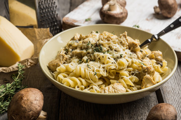 Fresh pasta with meat, mushrooms and herbs. On the rustic wooden background. Selective focus.