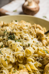 Fresh pasta with meat, mushrooms and herbs. On the rustic wooden background. Selective focus.
