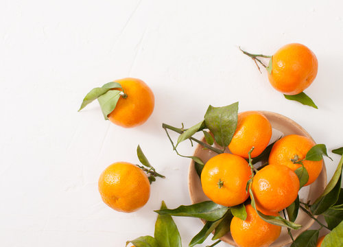 Fresh tangerines with green leaves on a white background