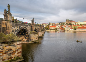 Fototapeta na wymiar Prague, Czech Republic - October 13, 2017: Dramatic cloudy autumn view of Charles Bridge, Vltava river, St. Vitus Cathedral, Prague Castle and Old Town, Prague, Czech Republic. 