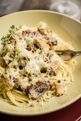Fresh pasta with meat, mushrooms and herbs. On the rustic wooden background. Selective focus.