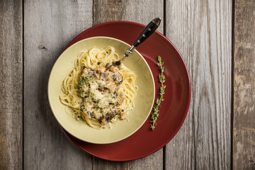 Fresh pasta with meat, mushrooms and herbs. On the rustic wooden background. Selective focus.