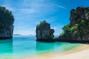 Naklejka premium steep cliffs, covered with greenery, beautiful sea and a view of the horizon in the Andaman Sea - a photo from the beach of the island of Hong, Thailand