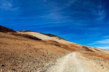 Teide National Park, Tenerife, Canary Islands - Gravel footpath of the Montana Blanca volcanic ascent trail. This scenic hiking path leads up to the 3718 m Teide Peak, the highest peak in Spain.