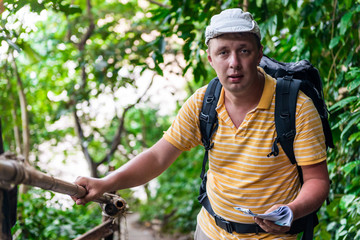 male tourist with a backpack in the jungle resting