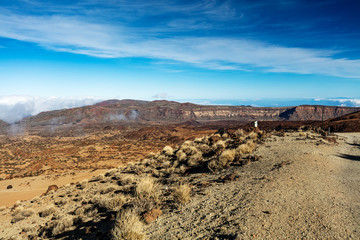 Teide National Park, Tenerife, Canary Islands - colourful soil of the Montana Blanca volcanic ascent trail to the 3718 m Teide peak. The Teide astronomical observatory can be seen in the distance.