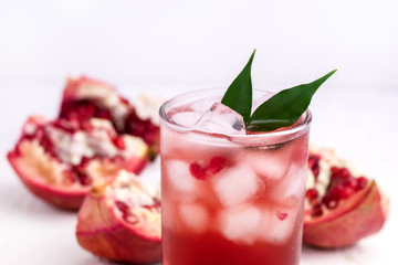 Glass of Pomegranate Juice with Ice and Fresh Pomegranate Fruits on White Backgroud Healthy Detox Drink Close Up