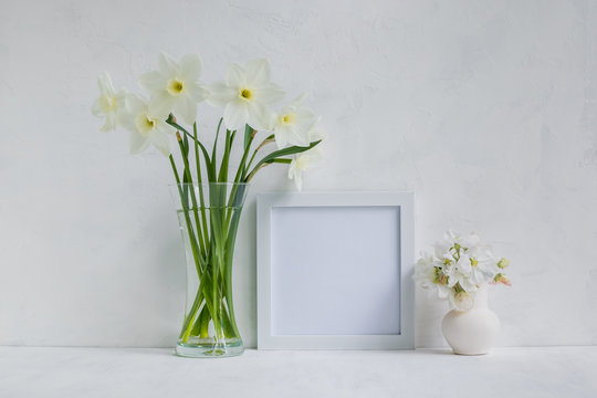 Mockup with a white frame and white daffodils