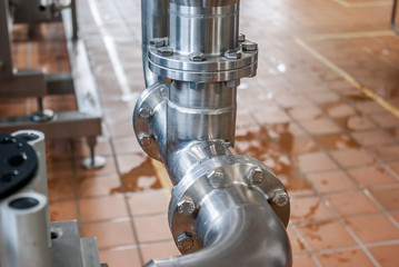 Connection of stainless steel pipes with bolts. Brilliant surfaces.