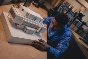 Young confident African American black male architect working on a private house project in the...