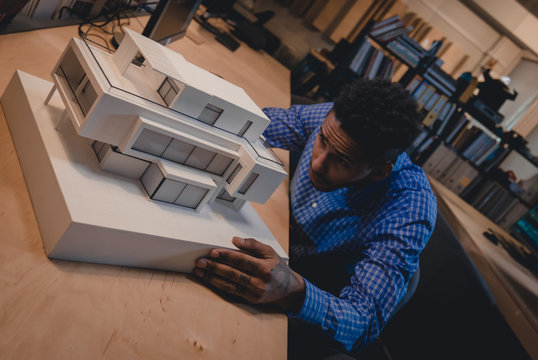 Young Confident African American Black Male Architect Working On A Private House Project In The Office, Studying Mansion Model