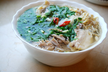 Bun Thang - traditional vietnamese rice noodles with shredded chicken, ham and eggs which is garnished by chopped cilantro, spring onion and chili slices.