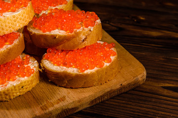 Sandwiches with red caviar on a cutting board