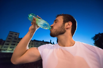 man drinking water after running session