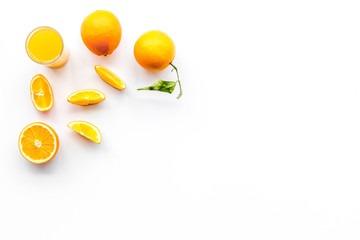 Orange juice in glass near slices of oranges on white background top view copyspace