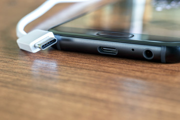 New fast USB Type-C port on mobile phone and cable close-up