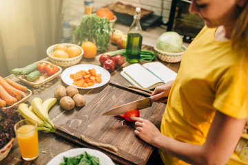 Young woman cooking on recipes, healthy bio food
