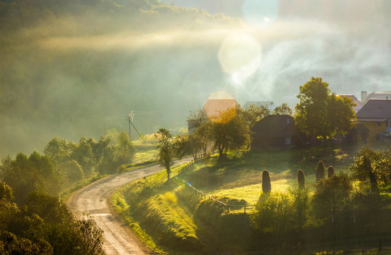smoke and fog over the village at sunrise. beautiful rural scenery near the road in mountainous area